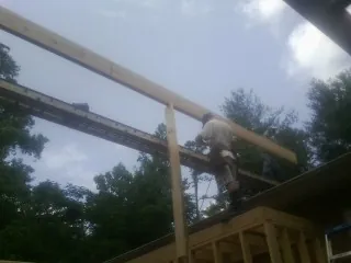 Carpenter setting a ridge beam over a new addition frame — Ice Dam Removal by Roofing Brothers in Royal City