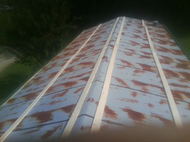 Rusted metal roof panels with new wood purlins before replacement — Storm Damage Roof Repair in Royal City by Roofing Brothers