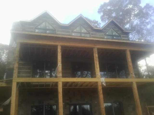 Dormers and porch framing on a large log home under construction — Roof Coating work by our crew in Royal City
