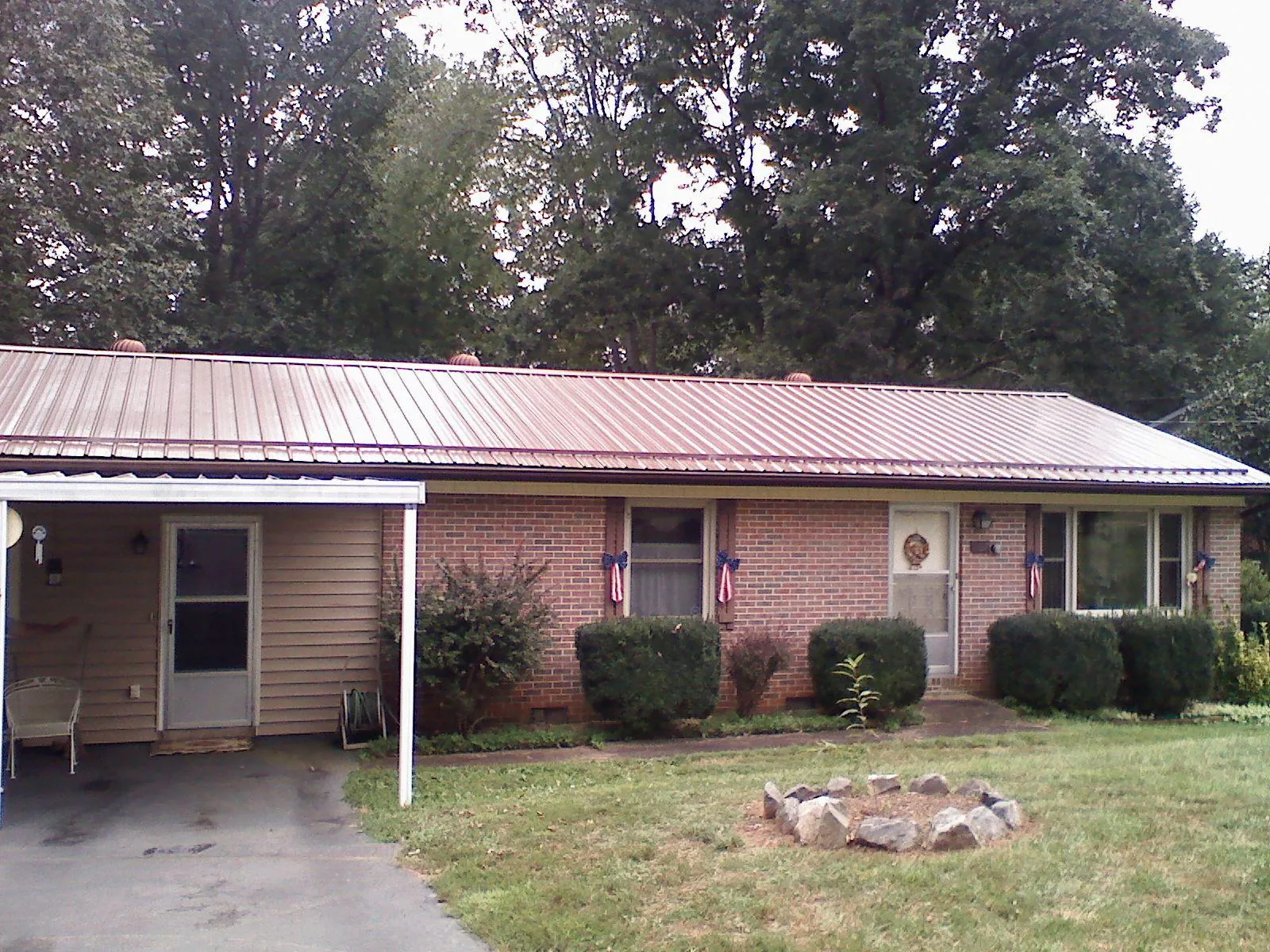 Bronze metal roof and carport on a brick ranch home — Roof Repair work by our crew in Royal City